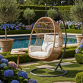 Hand-woven rattan hanging egg chair styled in a luxury garden
