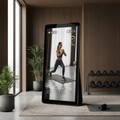 Full length smart fitness mirror showing workout class on HD display in luxury home gym